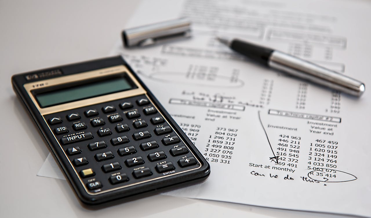 creative Close-up of financial documents with calculator and pen, ideal for business management themes.